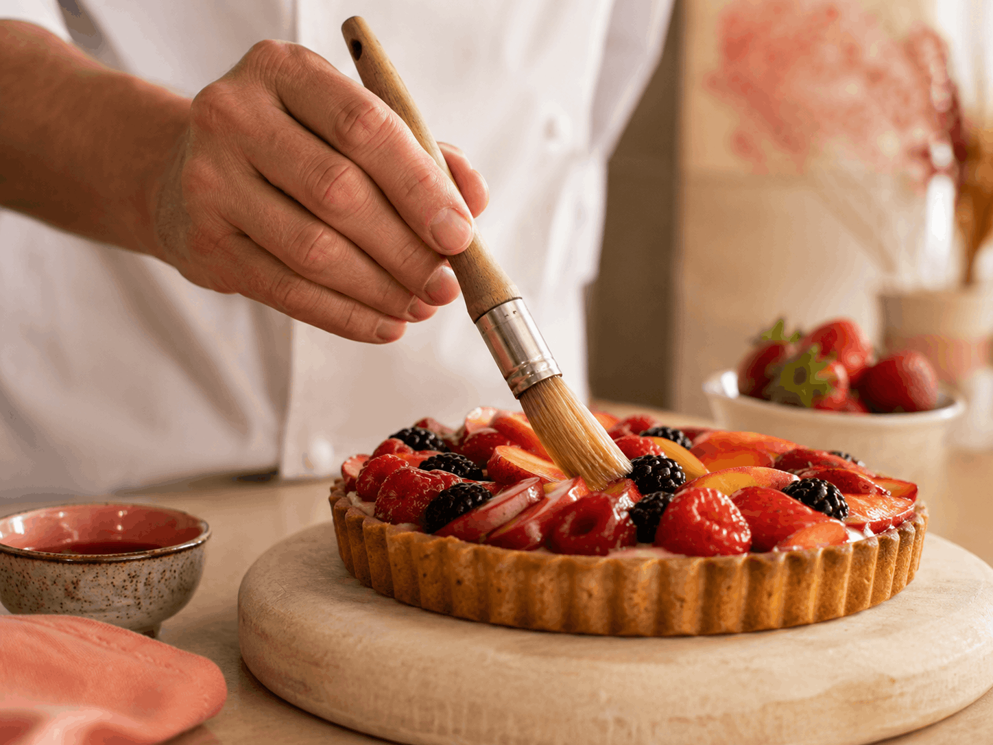 Tarte mit Beeren wird mit feinem Pinsel glasiert